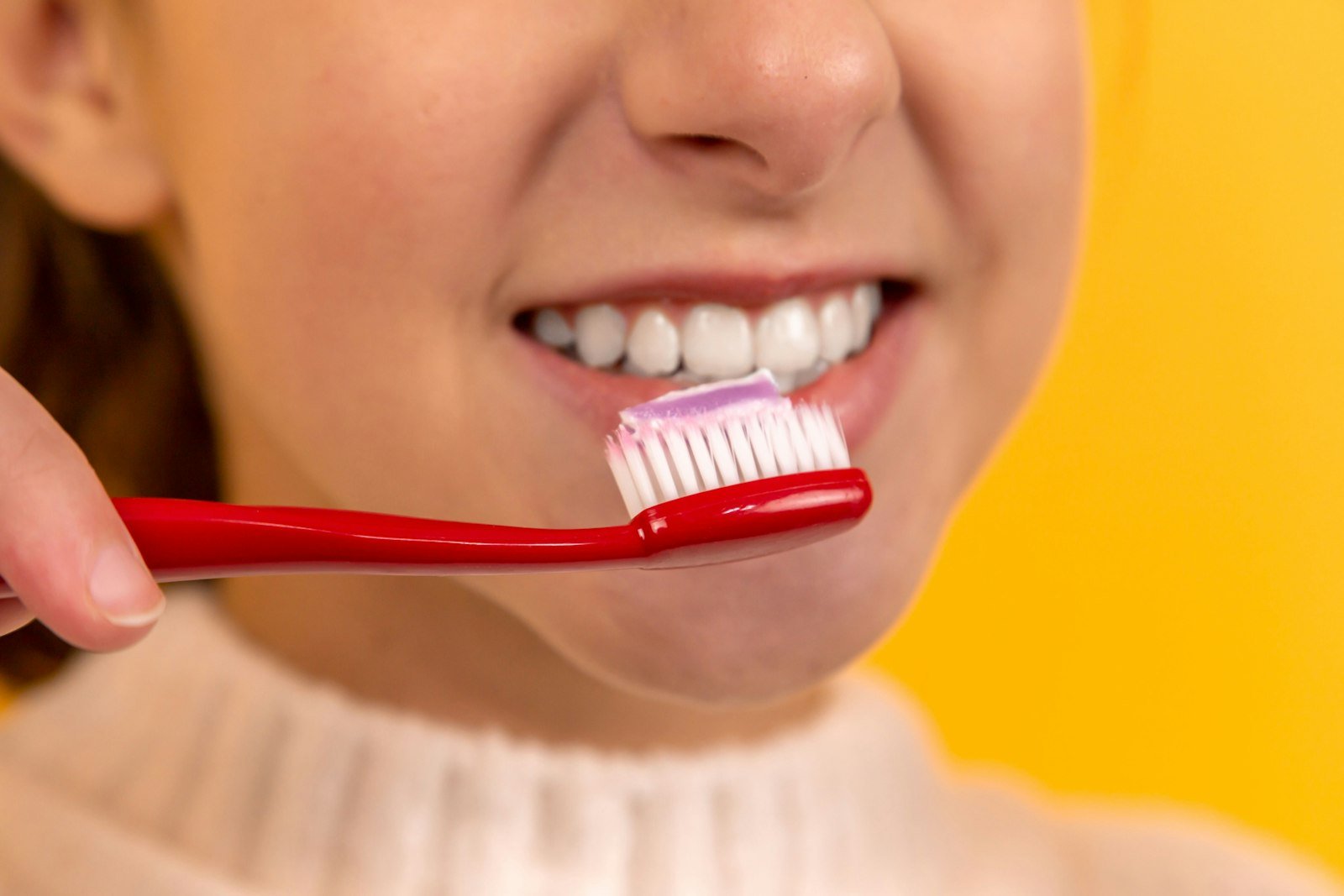 Close up of person brushing teeth with toothbrush
